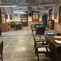 Wide interior view of the government office set with staff desks, file shelves and tiled flooring