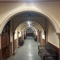 Long arched corridor with wooden waiting benches and stone-tiled floor in Stage 04 Government Office Set