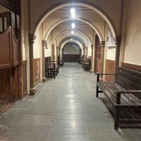 Government office corridor with repeated arches, wooden doors and waiting benches at Bhajanlal Estate