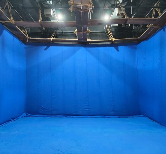 Blue chroma floor at Studio Floor #2, Malad Link Road, with full-height backdrop and overhead rigging.